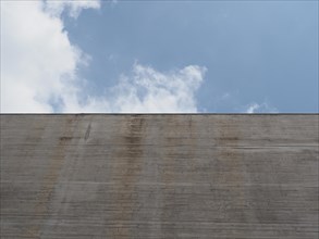 Grey concrete wall over blue sky background