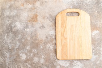 Empty rectangular wooden cutting board on brown concrete background. Top view, copy space, flat lay