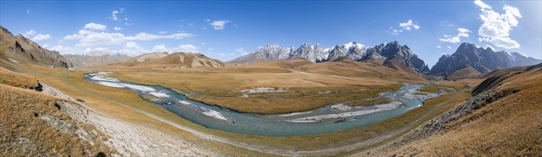 Panorama, mountain landscape with yellow meadows and Kol Suu river, mountain peak with glacier,
