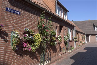 Street with floral decorations in Greetsiel, Germany, Europe