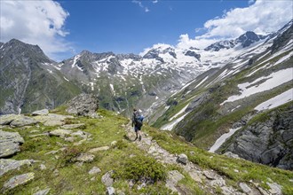 Mountaineer on hiking trail in picturesque mountain landscape, in the background mountain peak