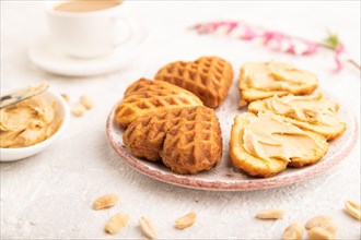Homemade waffle with peanut butter and cup of coffee on a gray concrete background. side view,