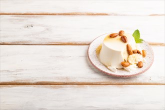 Ricotta cheese with honey and almonds on white wooden background. side view, copy space