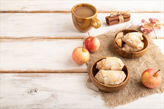 Homemade sweet cookie with apple jam and cup of coffee on white wooden background and linen textile