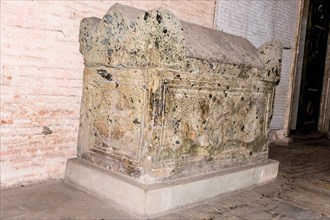 Unmarked ancient sarcophagus in front of wall in public mosque in Istanbul, Turkiye