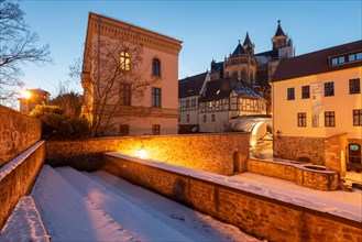 Historic courtyard of the Moellenvogtei, behind it half-timbered houses and cathedral at dusk,