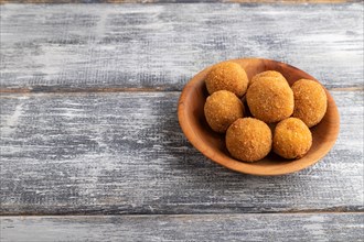 Meat balls on a wooden plate on a gray wooden background. Side view, close up, copy space