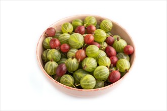 Fresh red and green gooseberry in ceramic bowl isolated on white background. side view, close up