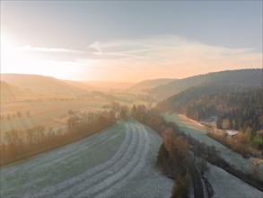 Dawn over a peaceful landscape of fields, forests and misty hills, Nagold, Black Forest, Germany,