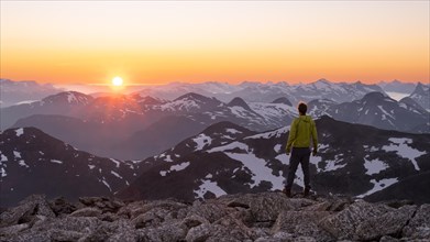 Mountaineer enjoying the view, mountain panorama at the summit of Skala at sunset, sun setting
