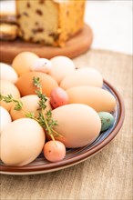 Homemade easter colored eggs on plate and raisins cake on a gray concrete background and linen