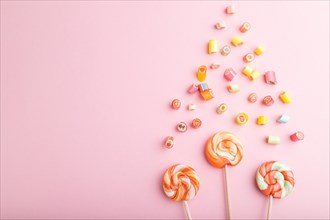 Various caramel candies on pink pastel background. copy space, top view, flat lay