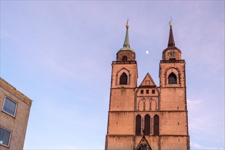 Pink-coloured sky behind the twin towers of St. John's Church at dusk, Magdeburg, Saxony-Anhalt,