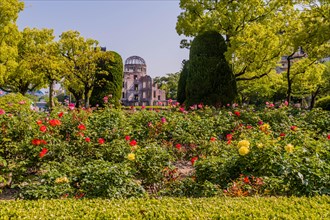 Landscape of flower garden at Peace Memorial Park with A-bomb dome in background in Hiroshima,