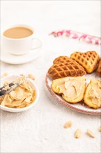 Homemade waffle with peanut butter and cup of coffee on a gray concrete background. side view,