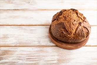Fresh homemade golden grain bread with wheat and rye on white wooden background. side view, copy