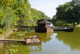 Museum of the watermill next to water lilies under green tree branches, Kolarovo Ship Mill,