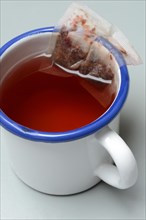 Red fruit tea in mug with tea bag, tea
