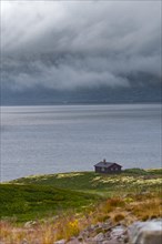 Shot of a hut on Lake Soenstevatn in the rain, portrait format, inland waters, log cabin, holiday
