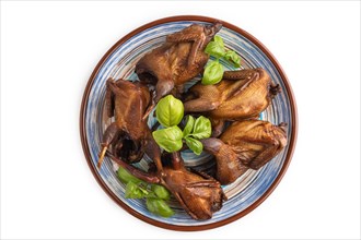 Smoked quails on a ceramic plate isolated on white background. Top view, flat lay