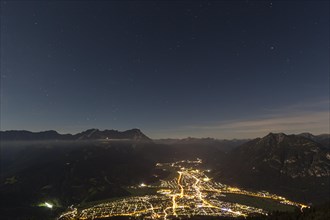 Night shot of an illuminated town in front of mountains, starry sky, Garmisch-Partenkirchen,