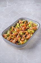 Bowl with iceberg lettuce salad with shrimp, mussels and avocado