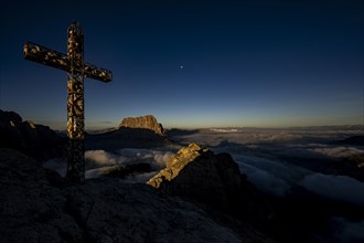 Summit cross of the large Cirrspitze with Dolomite peaks in the background, Corvara, Dolomites,