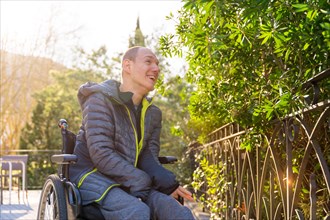 Low angle view portrait of a happy disabled man contemplating nature in an urban park in a sunny