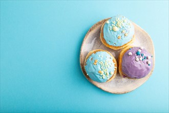 Purple and blue glazed donut on blue pastel background. top view, flat lay, copy space. Breakfast,
