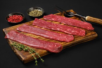 Raw beef strips on black background