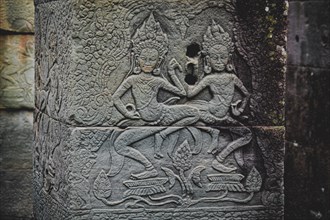 Weathered stone carving of Apsara dancers from the Angkor Wat temple in Siem reap, Cambodia, Asia