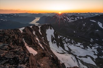 View of mountains and fjord Faleidfjorden, sun star at sunset, summit of Skala, Loen, Norway,