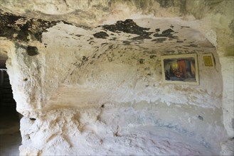 A rock cave with a mural and an information panel, abbot's cell, Aladja Monastery, Aladja