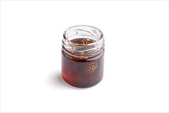 Pine cone jam in glass jar isolated on white background. Side view, close up