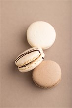 Brown and white macaroons on beige pastel background. top view, flat lay, close up, still life.
