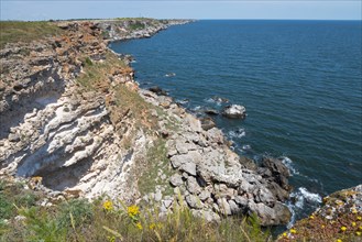 A steep cliff on a quiet coast with a view of the blue sea and clear sky, cliff, Kamen Bryag,