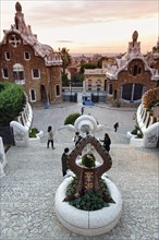 View from the dragon staircase of buildings with colourful mosaics, Park Güell entrance, dawn,