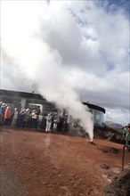Tourists watch steam rise from geyser spout, Parque Nacional de Timanfaya, national park,