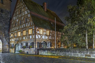 Historic half-timbered house from 1799, in the old town at night in autumn rain, Lauf an der