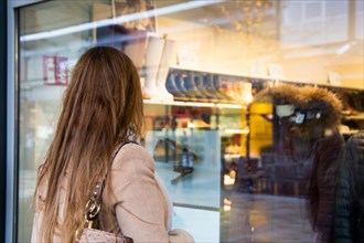 Symbolic image Shopping: Young woman standing in front of a shoe shop