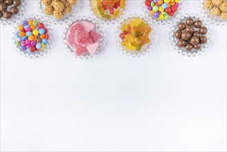 Sweets on small glass plates on a white background, copy room