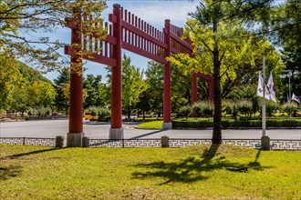 Large red wooden gate across four lane road in public park in South Korea