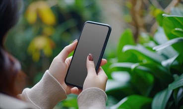Female hand holding smartphone with blank screen on nature background. Mock up AI generated