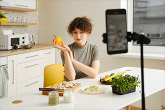 Professional nutritionist woman recording video for social media in her kitchen