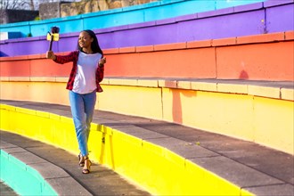 African female young social media content creation recording herself in a colorful urban park