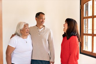 Adult children visit their Japanese-born mother, engaging in lively conversation and laughter while