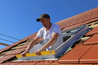 Employees of Zimmerei Mellein GmbH install the roof windows in the Mutterstadt development area,