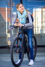 Young woman with bicycle in the city