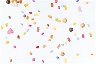 Colourful sweets fall against a white background