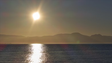 The rising sun over the sea near the horizon in a peaceful atmosphere, Gythio, Mani, Peloponnese,